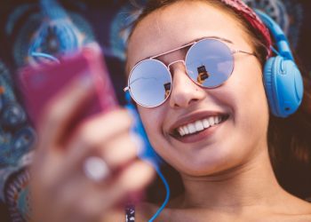 νέα γυναίκα ακούει μουσική από το κινητό